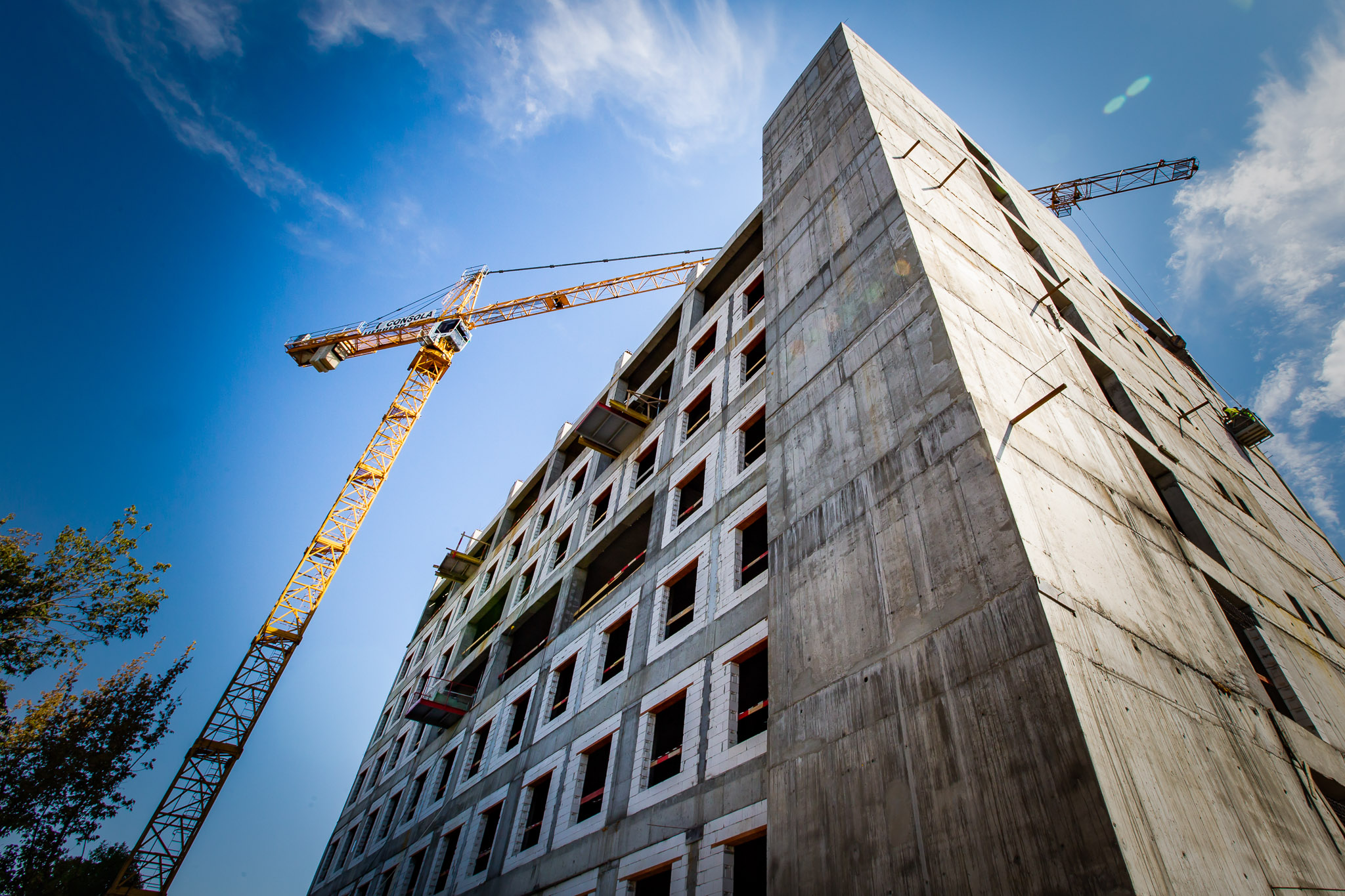cladire in constructie langa o macara turn galbena in cadrul unei sedinte foto industriala